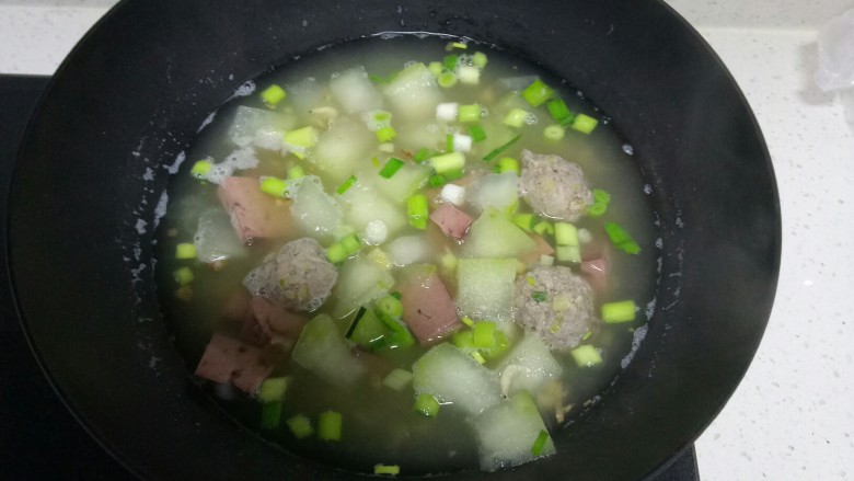 冬瓜🐷肝丸子虾米汤。,倒入蒜苗，根据个人口味加入适量盐，搅拌均匀，关火。