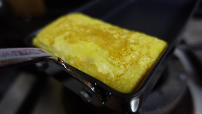日式厚蛋烧,最后收尾的时候借助刮刀往锅边靠，整形成为长方体，表面略金黄。