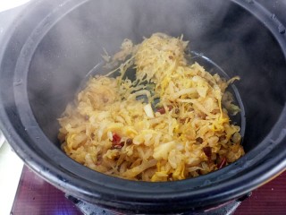 酸菜炖羊肉,炒好的酸菜倒入砂锅里
