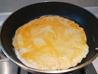 鸡蛋卷饼,翻过面后打入一个鸡蛋。