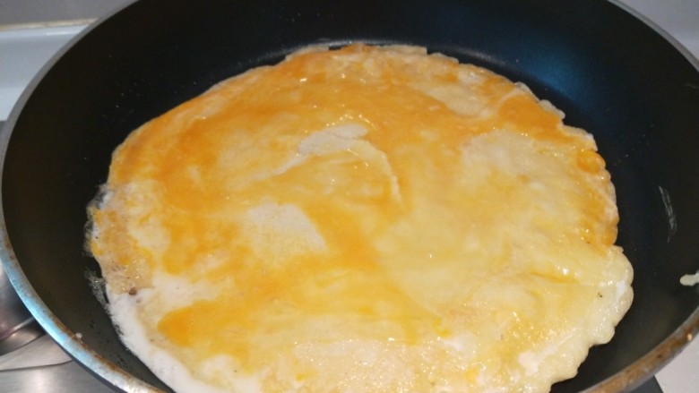鸡蛋卷饼,翻过面后打入一个鸡蛋。