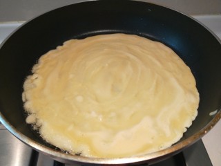 鸡蛋卷饼,在舀一大勺面糊摊开。