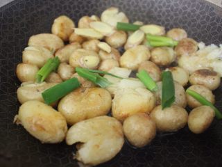 酱香小土豆,在煎好的小土豆上放入葱段、姜片