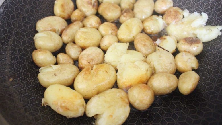 酱香小土豆,一直煎到小土豆两面都呈金黄色，用锅铲将小土豆压扁