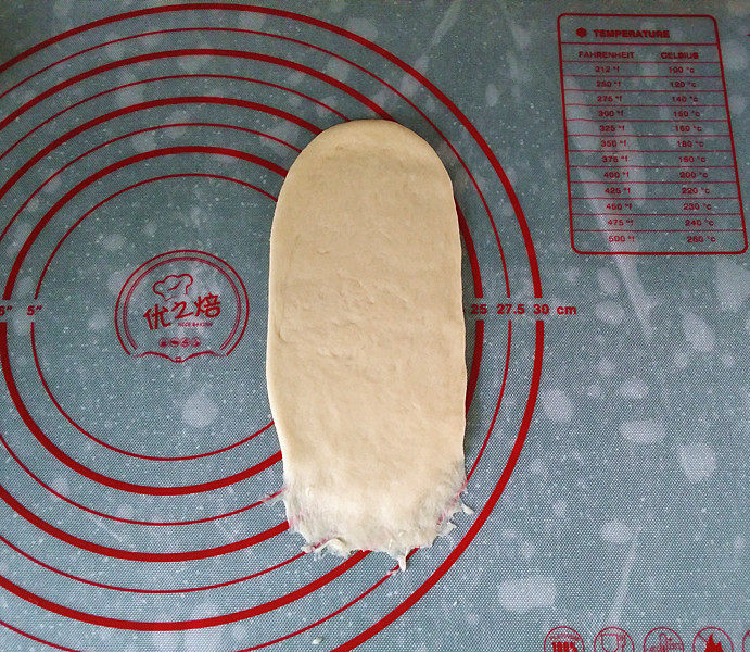 香葱火腿芝士面包,取一面团用擀面杖擀成长舌形、翻面后压簿底边