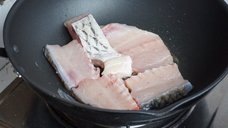 豆角焖鱼,炒锅里加油，烧热后，鱼放入。