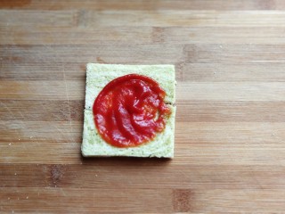 芝士培根三明治,在凹形中间抹上适量番茄酱