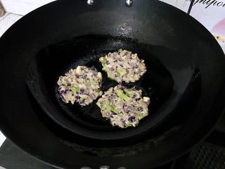 紫甘蓝鸡蛋肉饼,调小火，用小勺挖一勺，入锅中摊圆摸平。