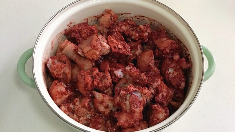 红糟焖猪蹄,然后用手抓匀，使红糟裹满每一块猪蹄，腌制1小时。