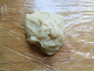 椰蓉豆沙糯米卷,在案板上铺上一张保鲜膜，放入蒸好的糯米团子，一定要带手套操作，不然黏乎乎粘在手上甩都甩不掉。