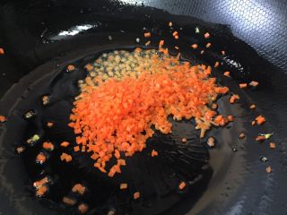 青豆胡萝卜蛋炒饭,锅里放少量的油，放入胡萝卜丁翻炒片刻