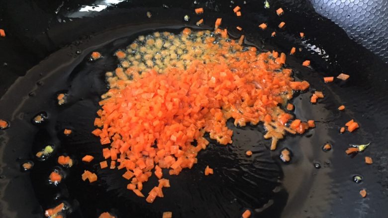 青豆胡萝卜蛋炒饭,锅里放少量的油，放入胡萝卜丁翻炒片刻
