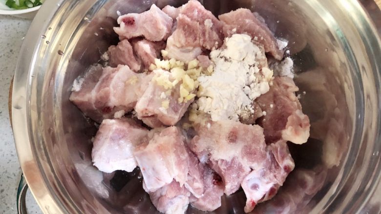 木耳蒸排骨,取一个较大而深的盘子，放入排骨，加蒜蓉、盐、糖、鸡蛋清、生粉、鸡精（介意可不加）。