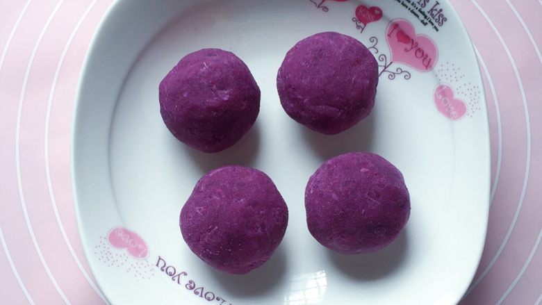 紫薯糯米饼,将紫薯泥也分为四份，每分为35克，然后滚圆
