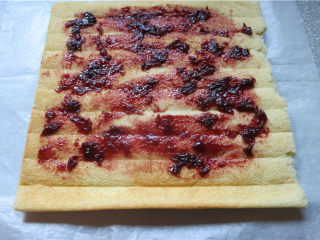 杂粮小四卷,基本凉透后台面上铺上油纸翻过来，抹上蓝莓酱