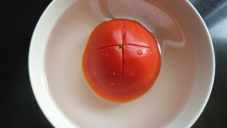 了不起的小番茄  番茄乌冬面,<a style='color:red;display:inline-block;' href='/shicai/ 59'>番茄</a>划十字，放入开水中浸泡。