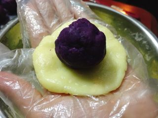 芝麻紫薯麻薯包,将紫薯泥和面团都平分成10份。
面团压饼，紫薯搓小圆。