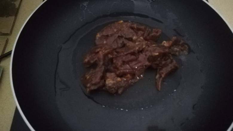 牛肉滑片盖饭,热锅热油，将腌制好的牛肉片倒入，快速翻炒