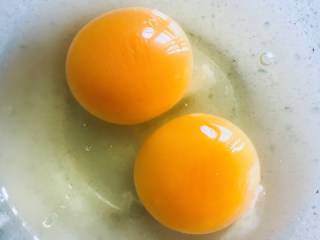秋葵厚蛋烧,将两个鸡蛋打入碗中。