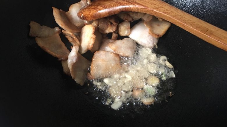干竹笋回锅肉,爆油后的肉片铲到一边，加入蒜姜片爆香。