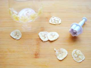 芒果香蕉思慕雪,香蕉切薄片，用花片模具刻出花朵贴在玻璃杯壁上。