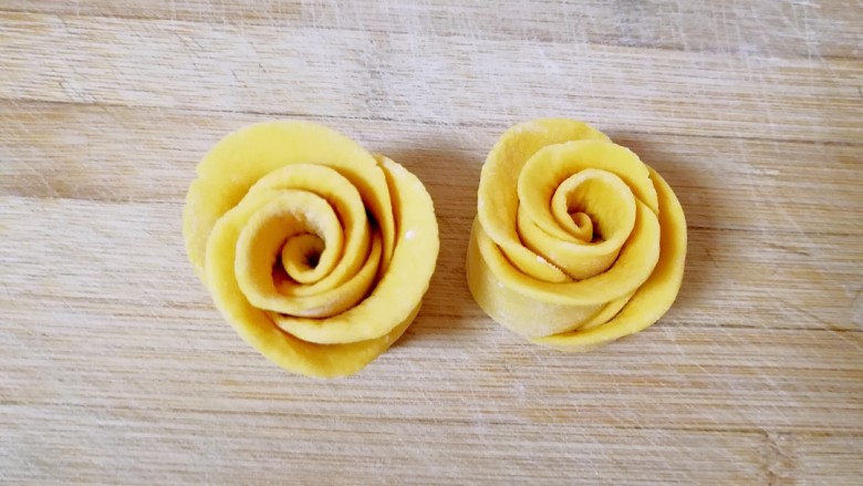 南瓜玫瑰花馒头,沿着筷子的压痕切开，切面朝下，整理一下玫瑰花的花瓣，漂亮的玫瑰花馒头就做好了，依次做完剩下的面团。
