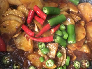 干锅土豆片,放入切好的青辣椒段，小米椒翻炒，最后加入盐，鸡精调味出锅
