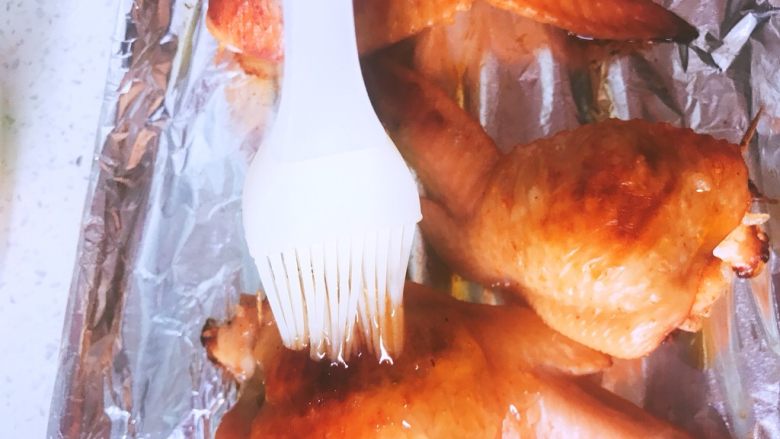 鸡翅包饭,20min后拿出，刷一层糖水或者蜂蜜也可以，将鸡翅翻面再次烤15min