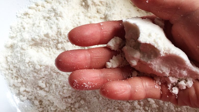 甜糯可口的双色松糕,加水搅拌的时候，吃不准到底要放多少，可以经常用手把粉捏成团试试，直到能把粉类捏成象图中的团（捏在手里不会马上松散开，但又不是实墩墩的那种）就可以了