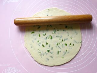饺子皮葱油饼,然后用擀面杖将叠好的饺子皮擀成一个大圆饼