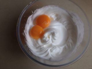 奥利奥小米海绵蛋糕杯,将蛋黄倒入打发好的蛋白霜里