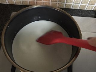 牛奶椰丝小方,将剩余的牛奶和淡奶油倒入锅中火加热并不停搅拌