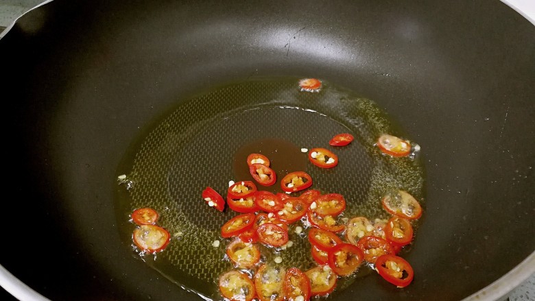 干贝蒸金针菇,锅里烧热油，倒入红椒圈爆香。