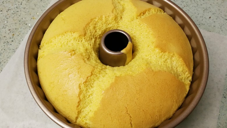 藜麦咕咕霍夫蛋糕（6寸）,烤好出炉，轻震两下模具。完美的中空圆模蛋糕，表面应该会出现十字对称型裂口。说明搅拌手法、蛋白霜的打发和烘烤温度时间都配合得刚刚好。