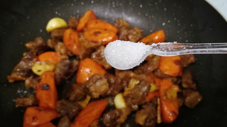 红萝卜焖牛腩,加入1小勺盐，翻炒均匀。