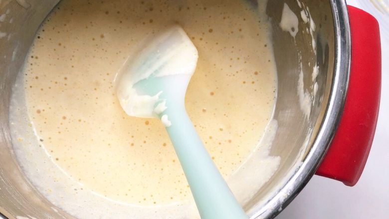 奶香玉米饼,将蛋液倒入面糊里，刮刀用翻拌的手法翻拌均匀，不可画圈圈搅拌以免消泡