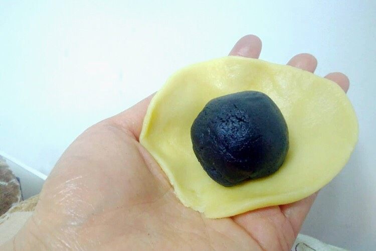 不用开酥酥的掉渣的黑芝麻蛋黄酥,把包好的黑芝麻蛋黄放在面皮上