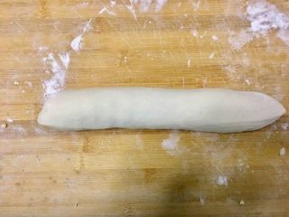 不用开酥酥的掉渣的黑芝麻蛋黄酥,从一侧卷起从长条状，分割成十份，用擀面杖用力轻一点擀出一个圆形备用