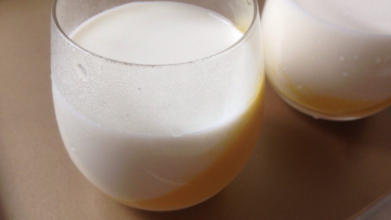 芒果牛奶布丁,将牛奶液倒入已经凝固的芒果液中放冰箱冷藏凝固。