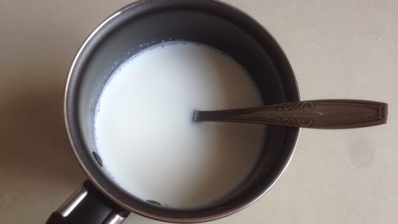 芒果牛奶布丁,250克牛奶加入糖，隔热水搅拌至糖融化。
