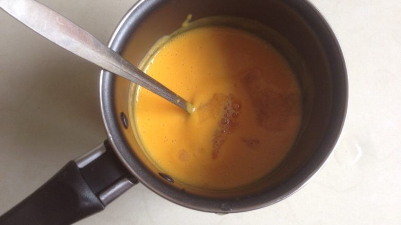 芒果牛奶布丁,加入挤掉水分的吉利丁片，搅拌其融化。