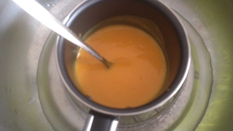 芒果牛奶布丁,隔热水加热芒果汁。