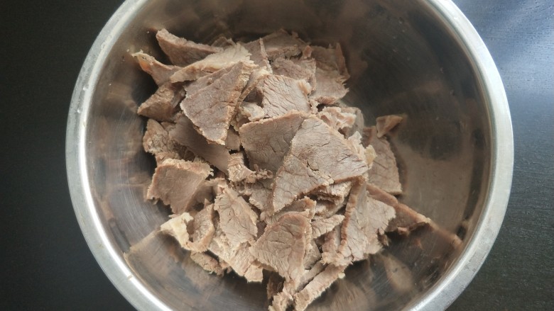 凉拌牛肉,牛肉顺着纹理切片，放入大一点的碗中。