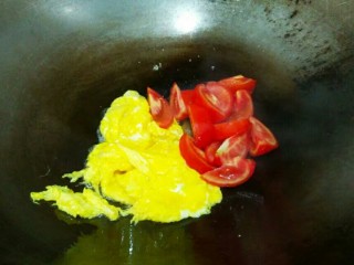 番茄鸡蛋粉丝,蛋液稍微凝固，刨到锅边 ，倒入番茄翻炒。