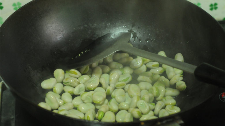 茴香蚕豆,另起锅，倒入食用油烧至6成熟时，倒入煮好的蚕豆进行翻炒