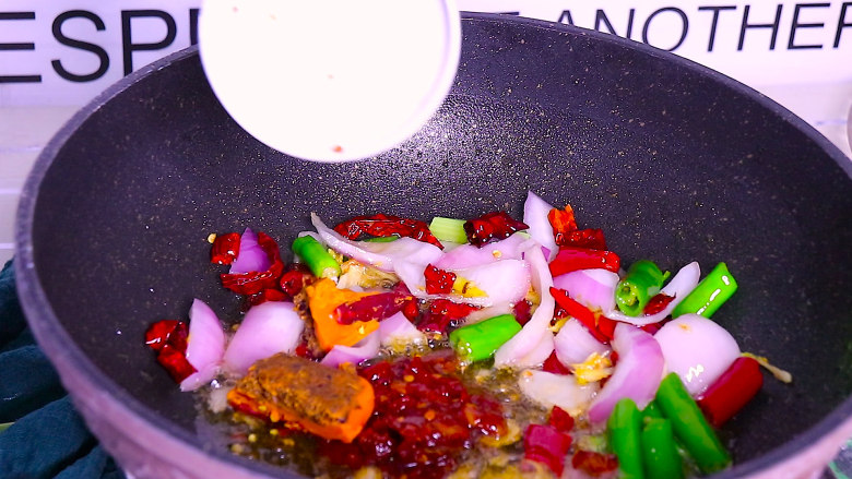 香辣干锅虾这样做秒杀饭店,再加入一勺豆瓣酱和一小块火锅底料，炒至火锅底料化开，炒出红油