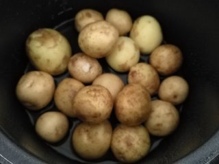 香煎小土豆,放入少量水，一勺盐拌匀，放入高压锅蒸12分钟。看过我食谱的朋友就知道，我一直这样蒸东西，省水，快。
