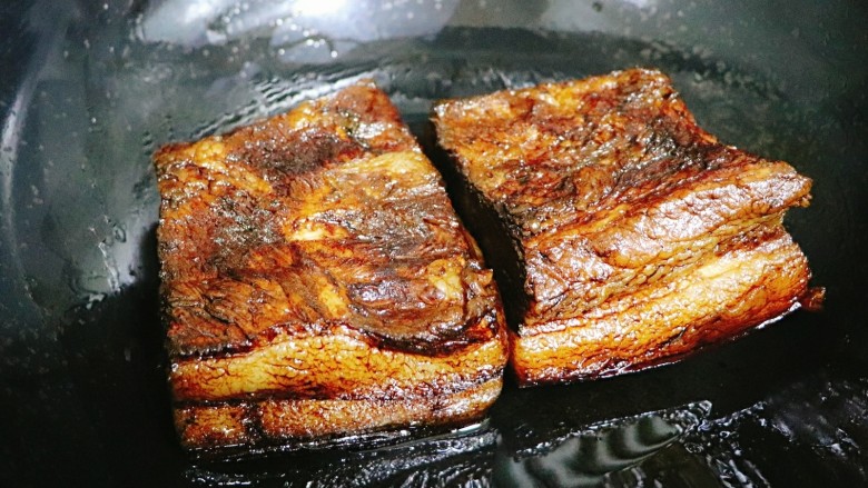 梅干菜扣肉,待表面老抽干了，肉皮朝下放入油锅，少许一点油，盖上盖小火煎三两分钟。
