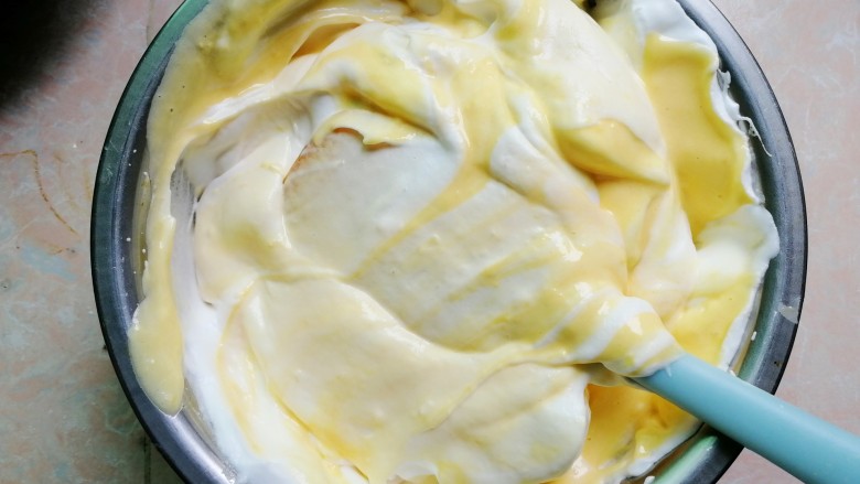玉米戚风蛋糕,最后把翻拌好的蛋黄糊全部倒入蛋白糊的盆里，继续翻拌均匀