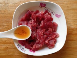 家常小炒四季豆,先将新鲜猪肉洗净，沥干水分，切成片放入盘中，然后加入一汤匙料酒